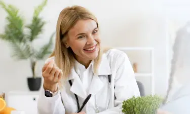 Minnesota family nurse practitioner smiling with pediatric patient during appointment